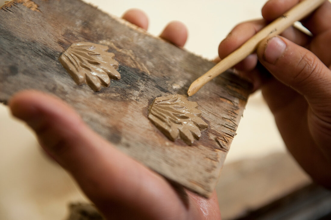 Close-up of human hand making clay art with stick at art school in Thimpu, Bhutan