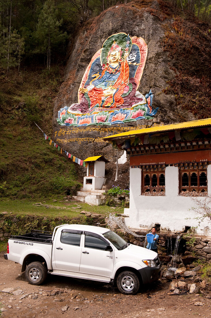 View of rock with Buddha painting and meditation house in Thimpu, Bhutan