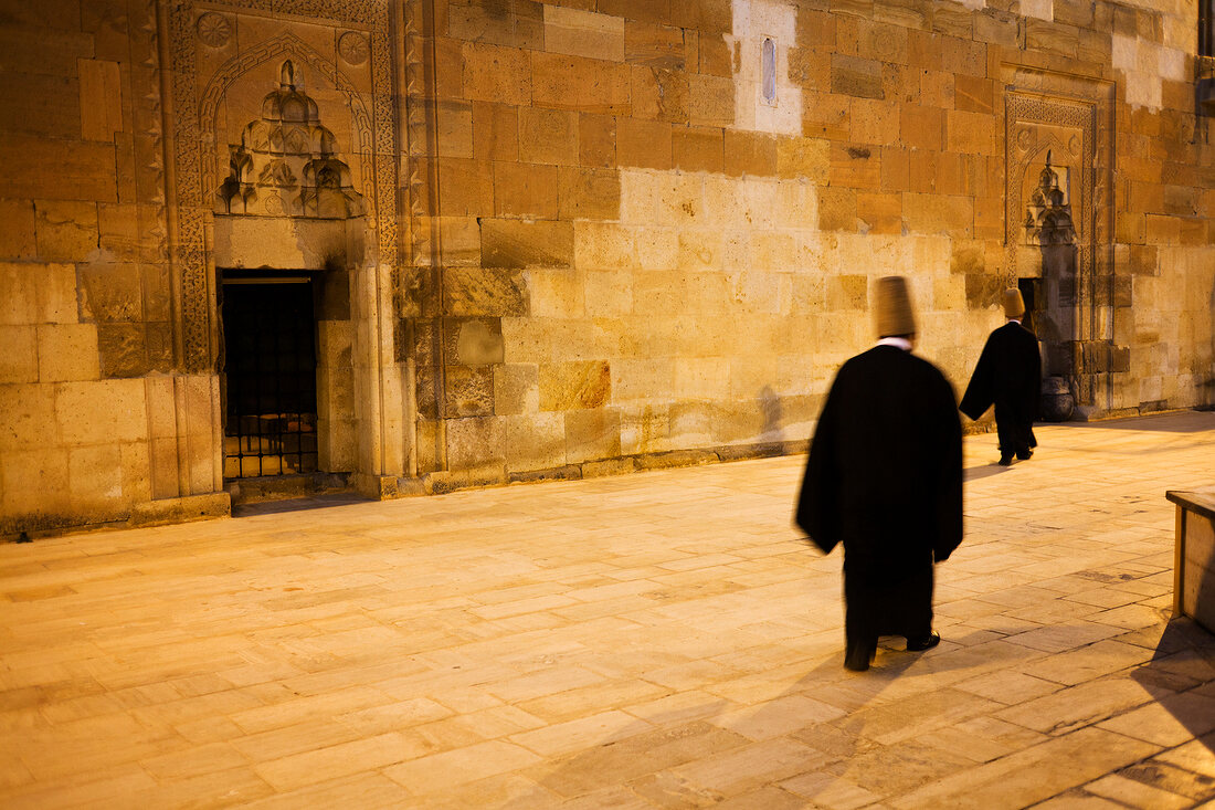 Dervishes walking in Sarihan Caravanserai, Cappadocia, Turkey