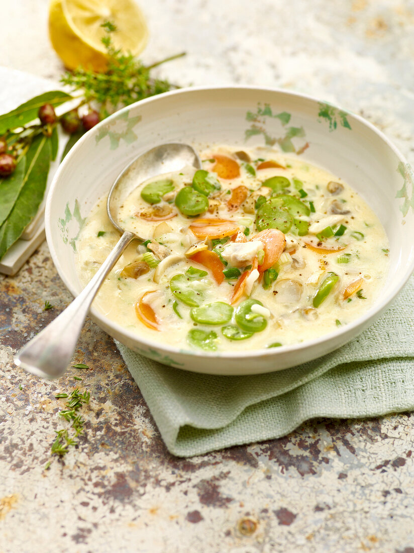 Lemon thyme soup with lima beans and spoon in bowl