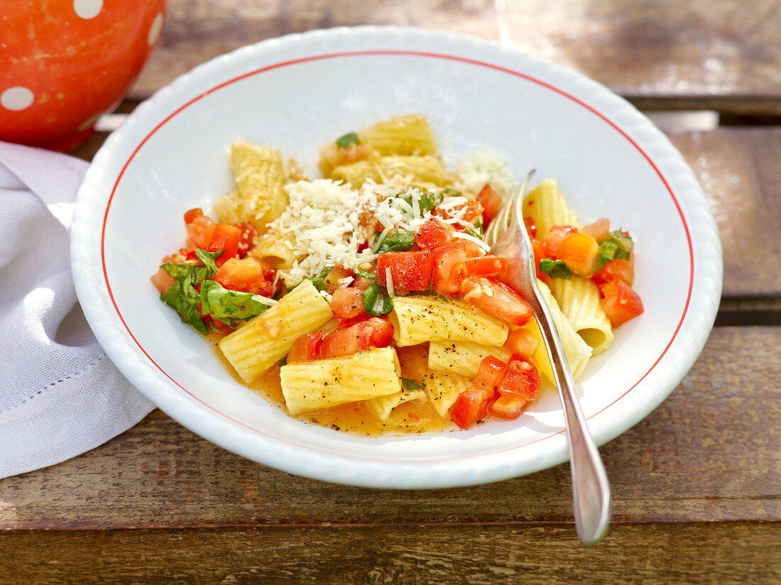 Rigatoni with fresh tomato sauce and spoon in serving dish