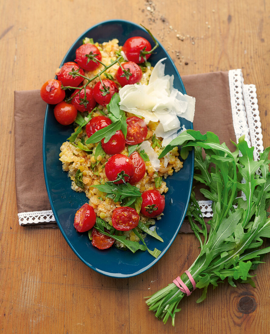 Lentil quinoa with baked tomatoes in serving dish, overhead view