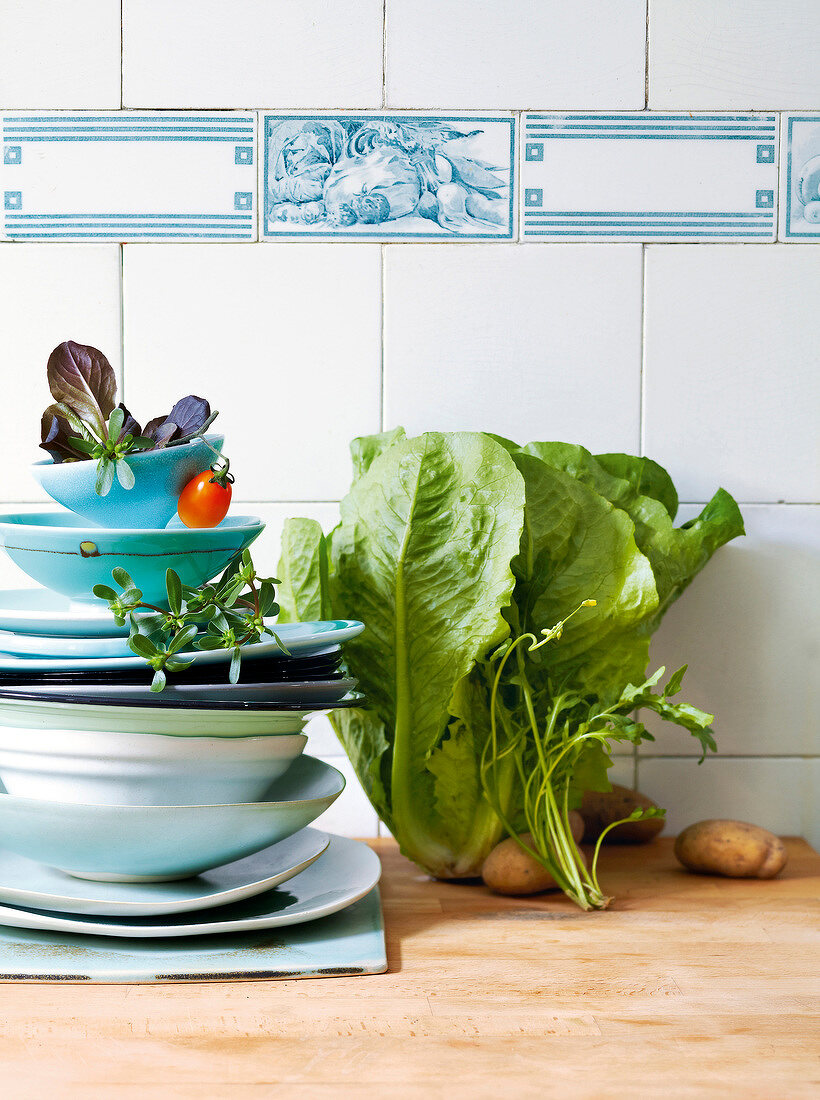 Lettuce leaves and stack of plates with vegetables