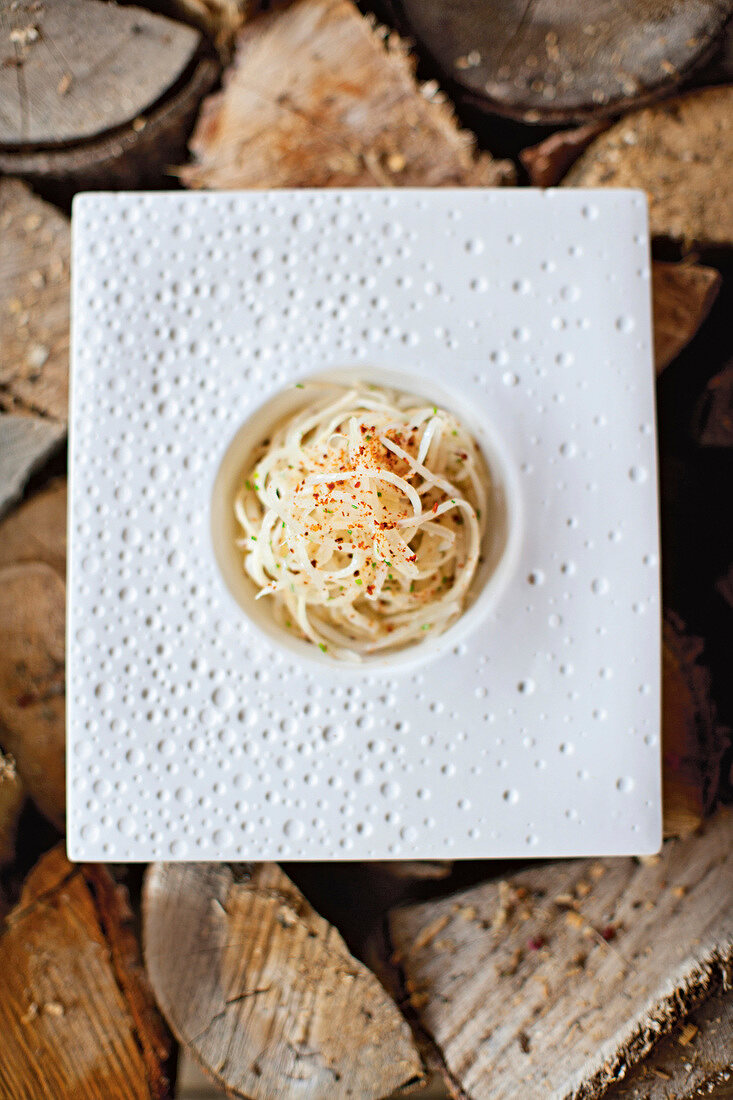 Salsify spaghetti with smoked bacon and parmesan on plate