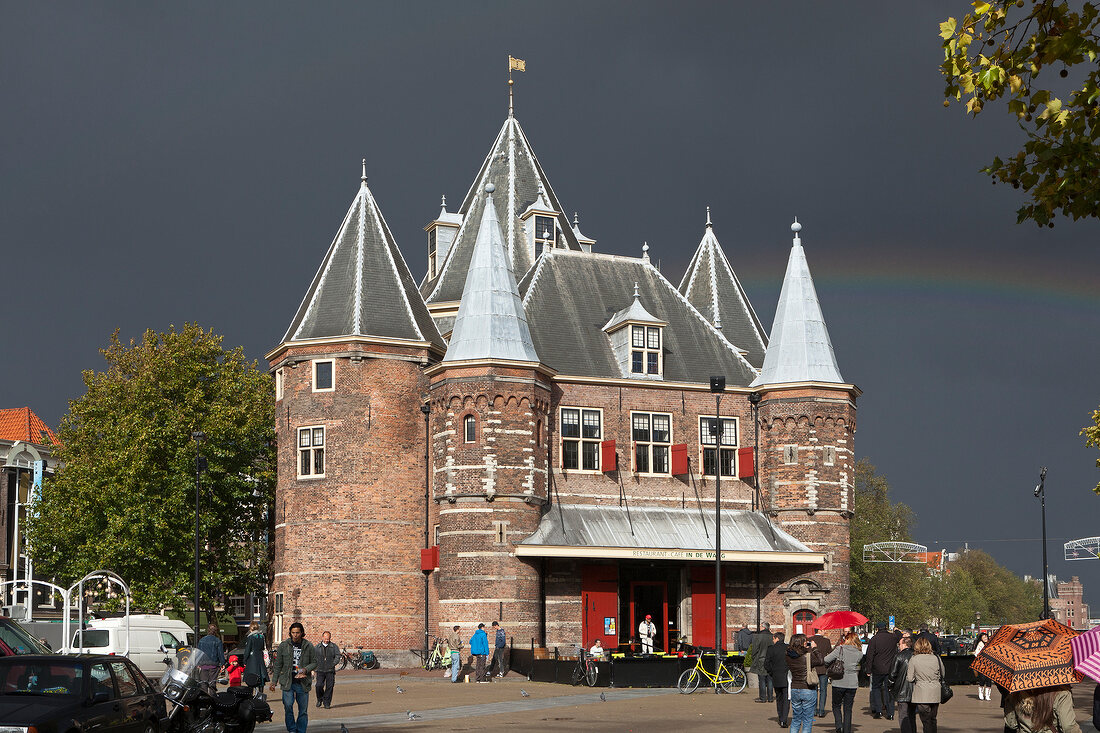 View of underpinning monument De Waag and rainbow in sky at Nieuwmarkt, Amsterdam