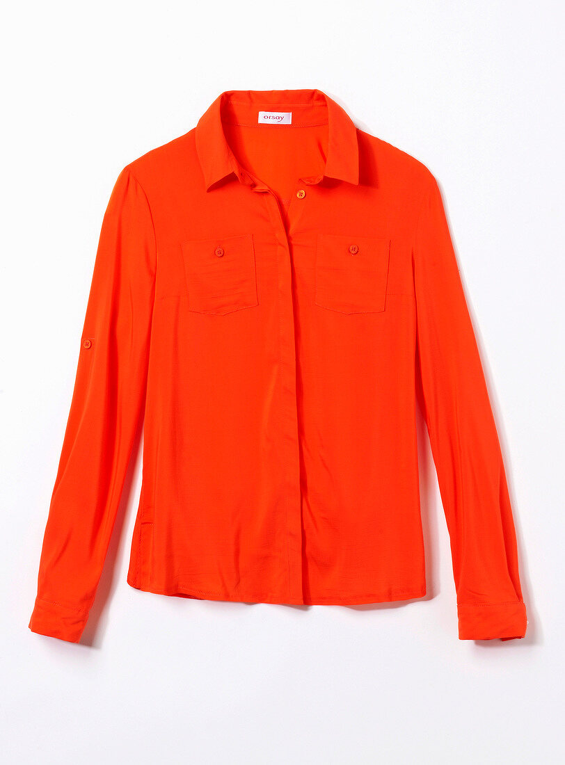 Close-up of orange shirt blouse with chest pocket on white background