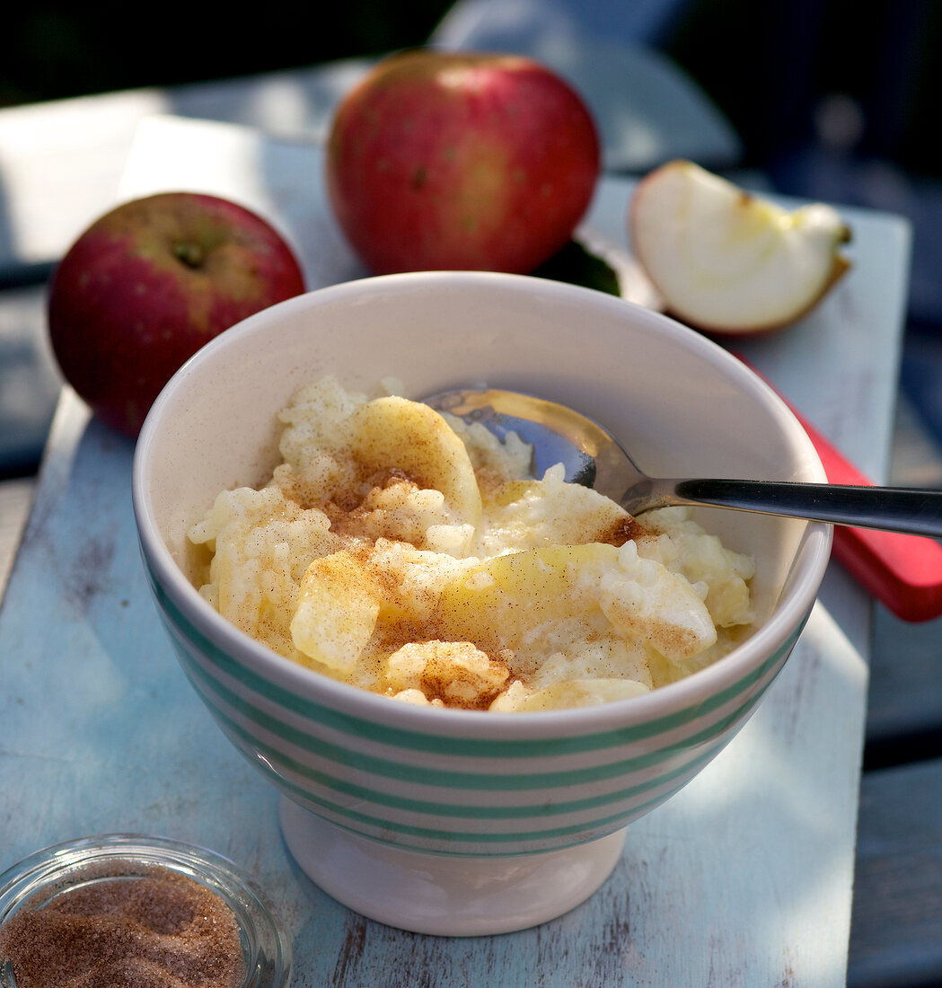 Close-up apple rice pudding with cinnamon sugar in bowl
