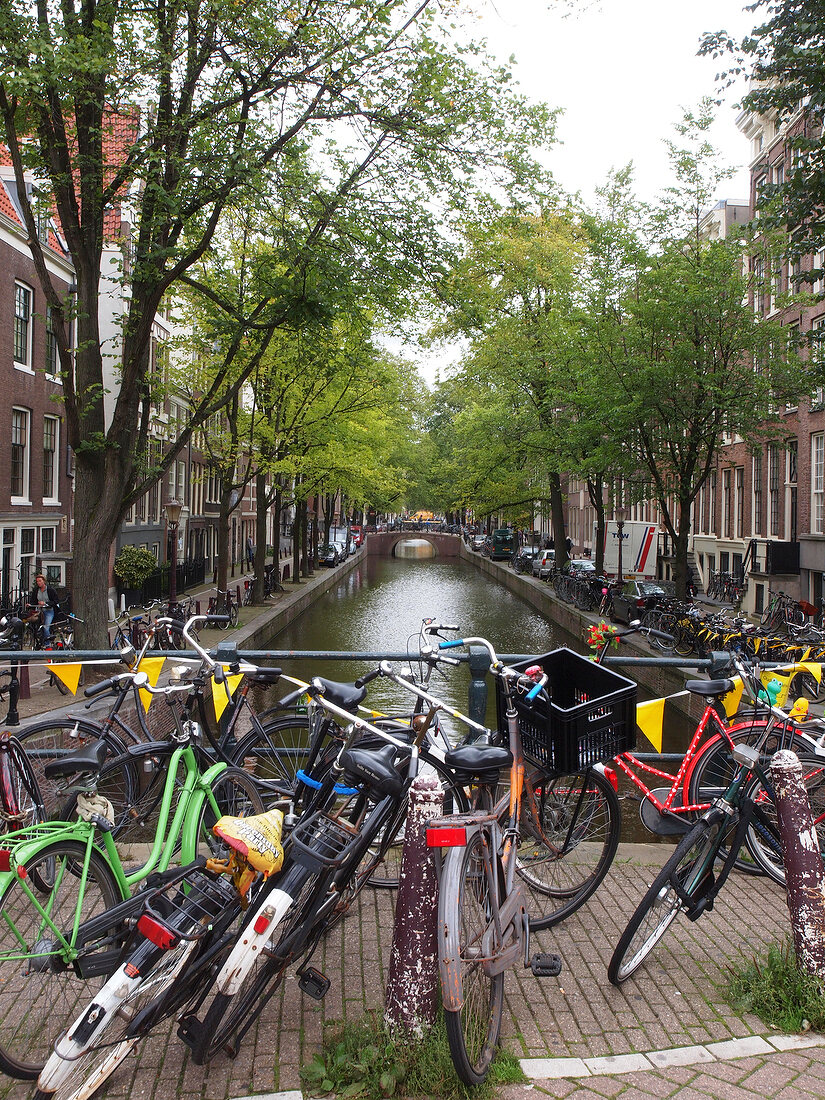 View of bicycles parked at city centre and on canal, Amsterdam, Netherlands
