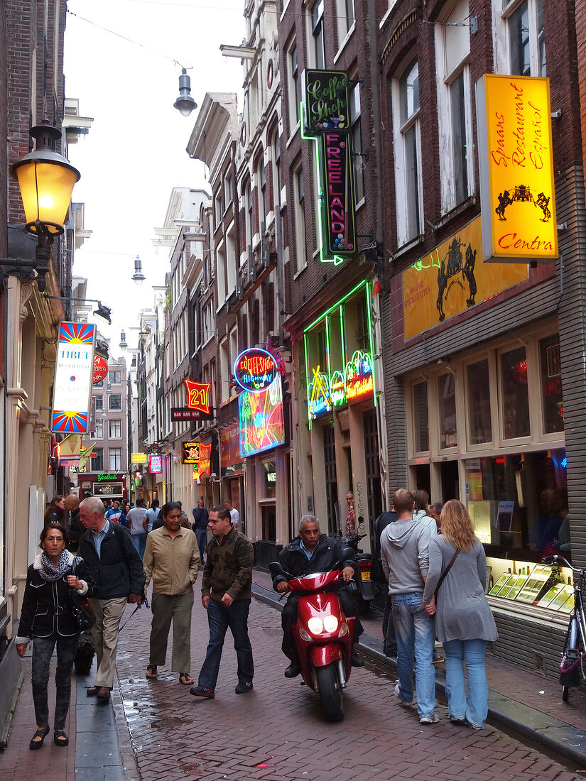 View of tourists in alley with different bars in Binnenstad, Amsterdam, Netherlands