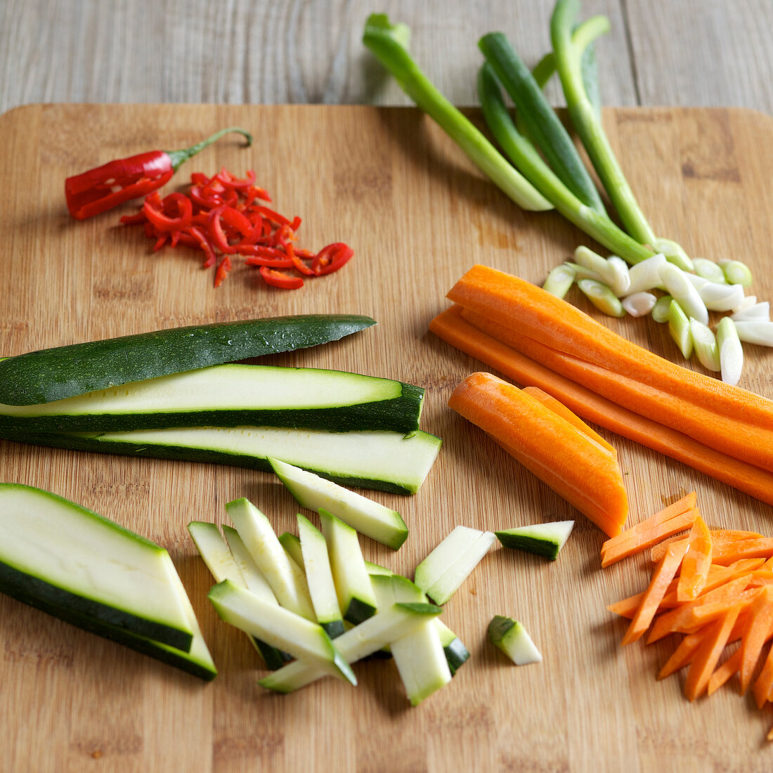 Close-up of sliced zucchini, carrots and red chilli on chopping board, step 2