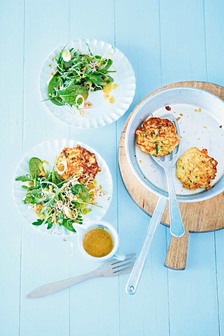 Courgette cakes with a spinach salad and radish sprouts