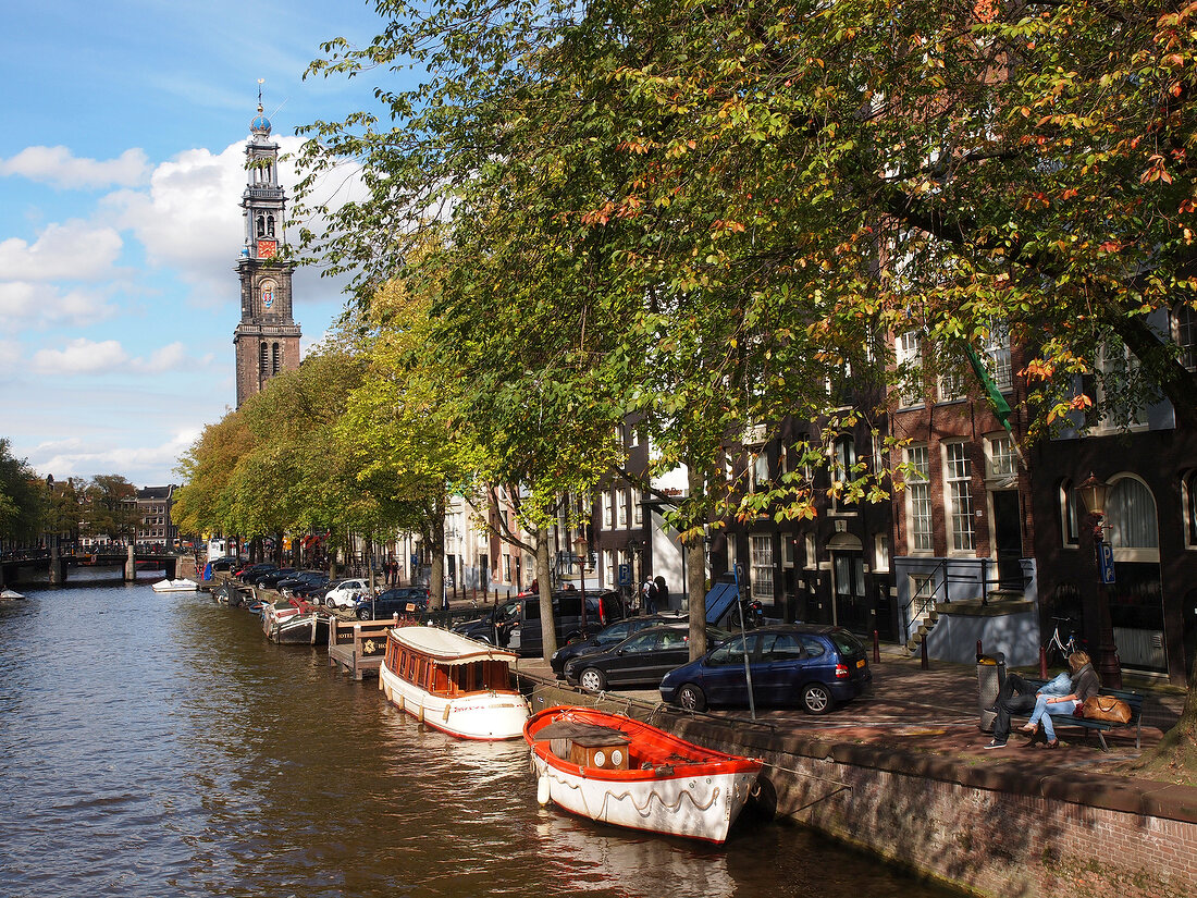 View of Westerkerk and boats moored in Prinsengracht canal, Amsterdam, Netherlands