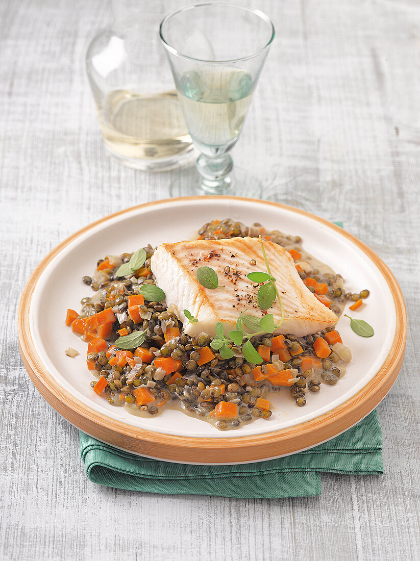 Halibut fillets with carrots and lentils on plate