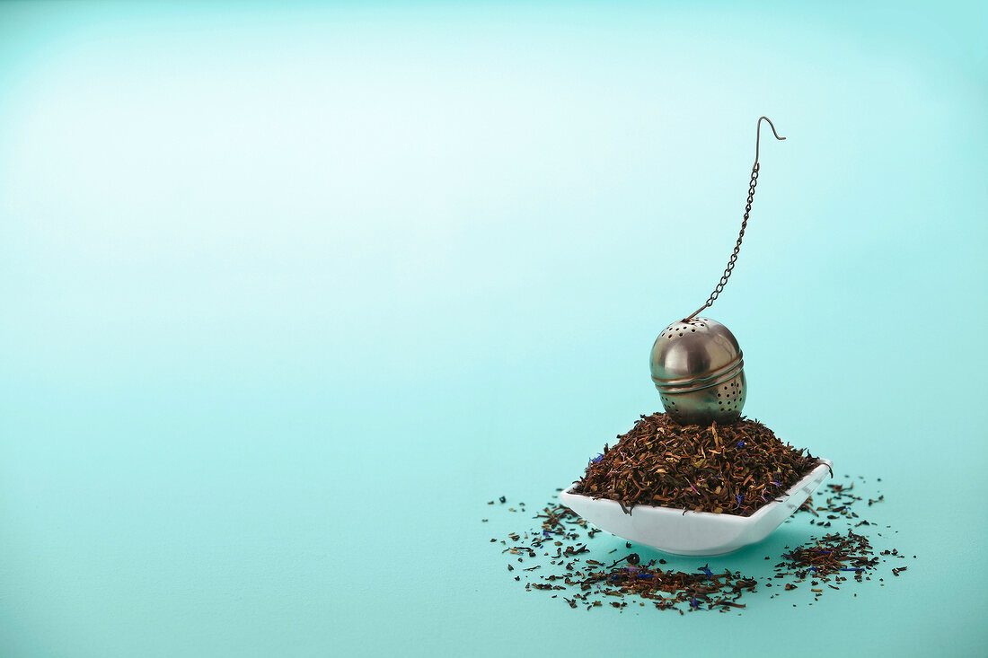 Bowl of tea leaves with tea strainer