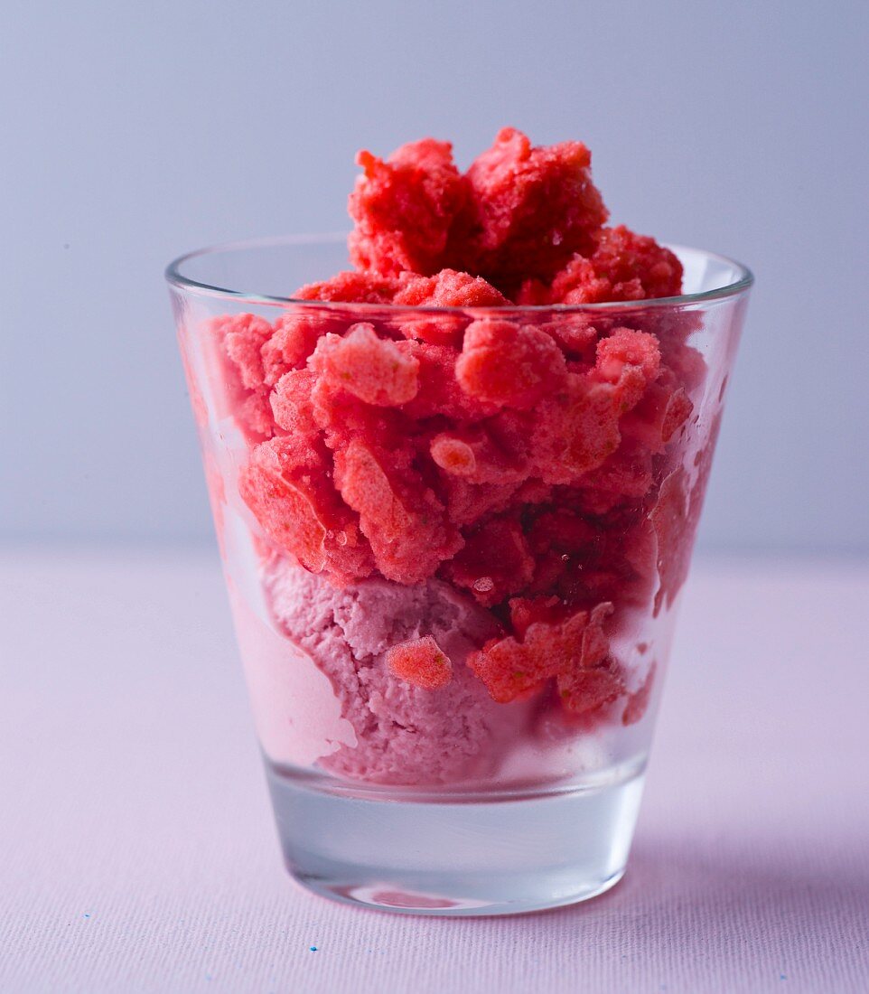Strawberry ice cream and strawberry granita in a desert glass (close-up)