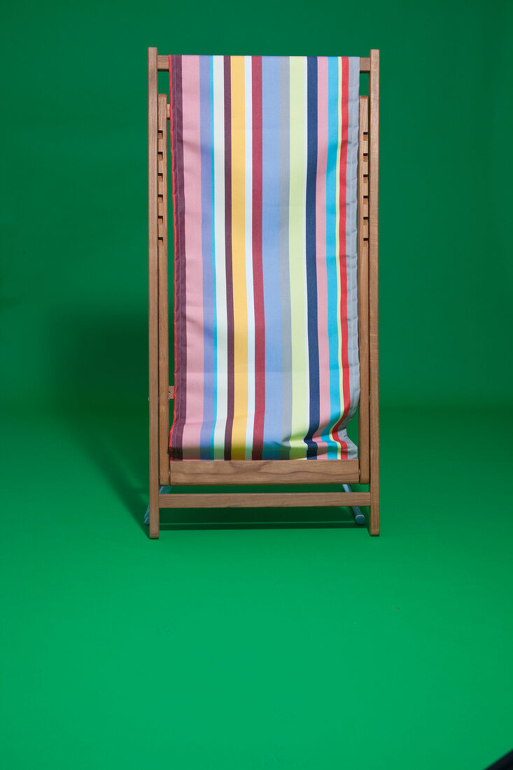 Striped beach chair on green background