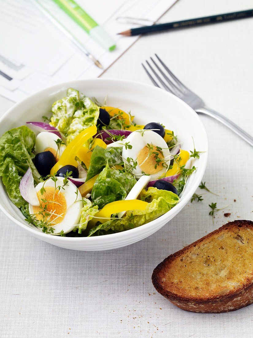 Blattsalat mit Eiern, Paprika, Oliven & Knoblauchbrot