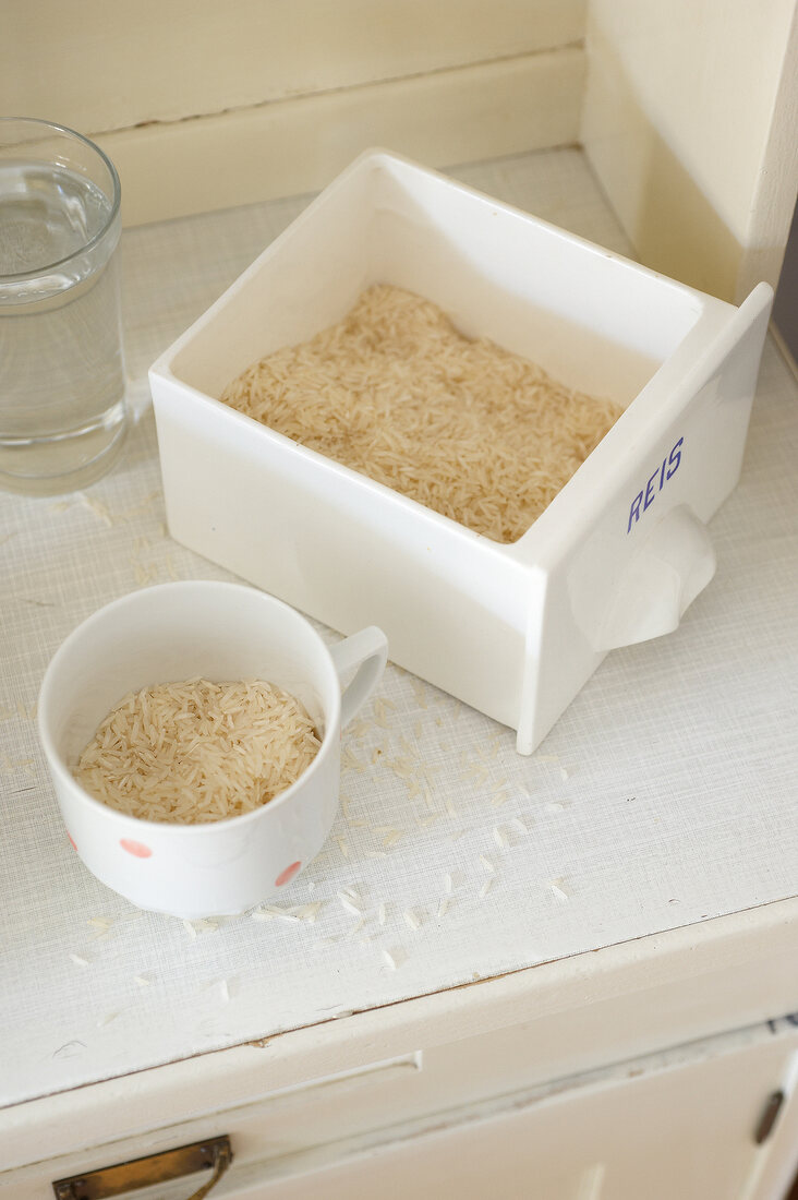Rice in cup and tray on wooden platform