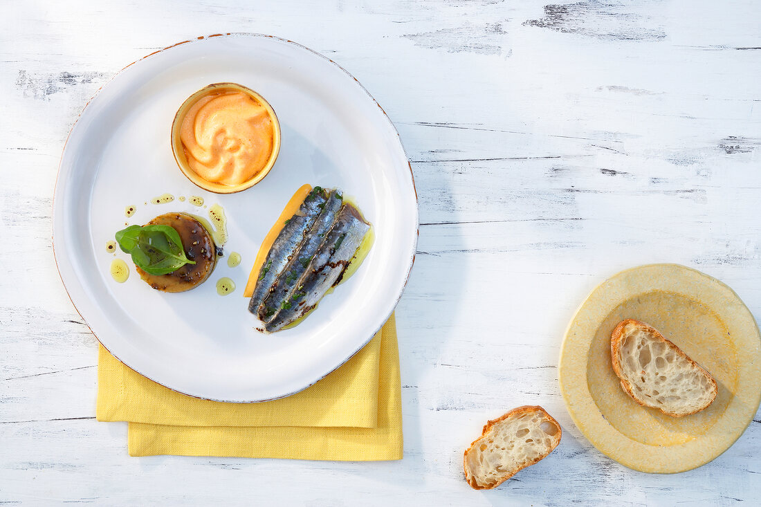 Sardines alimados with gazpacho jelly and pepper sauce on plate