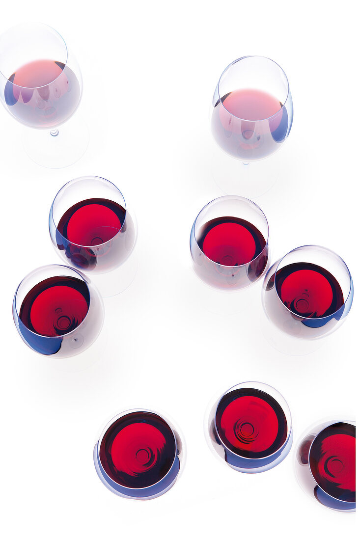 Glasses of red wine on white background