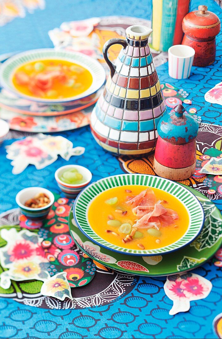 Möhren-Trauben-Suppe auf bunt dekoriertem Tisch