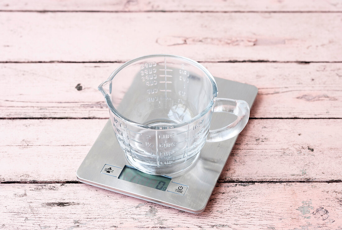 Empty measuring cup on kitchen scale