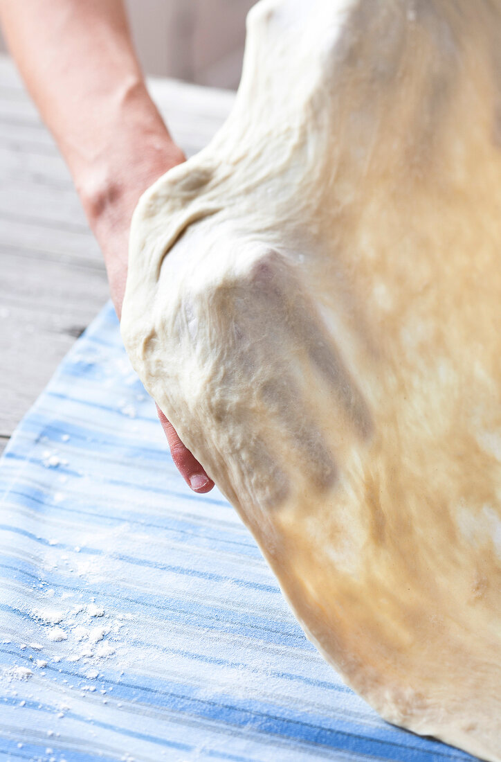 Strudel being laid on cloth for preparing cheese cake, step 1