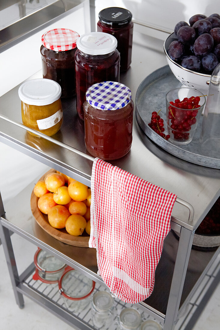Jam jars and glass of cherries on trolley
