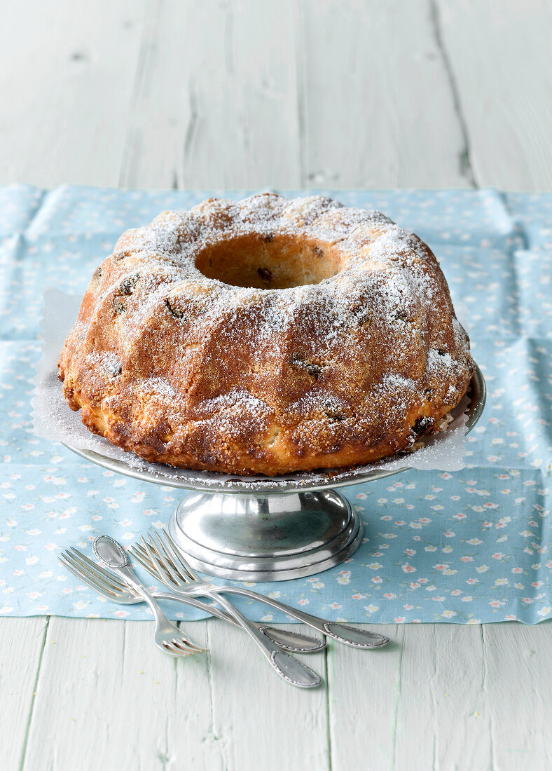 Curd bundt cake with icing sugar on cake stand