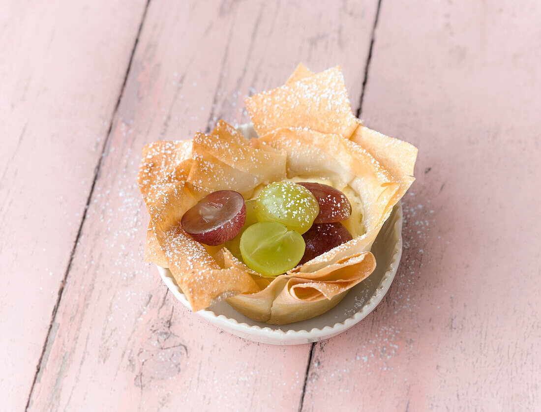 Swirl cheese cake with grapes in bowl on wood