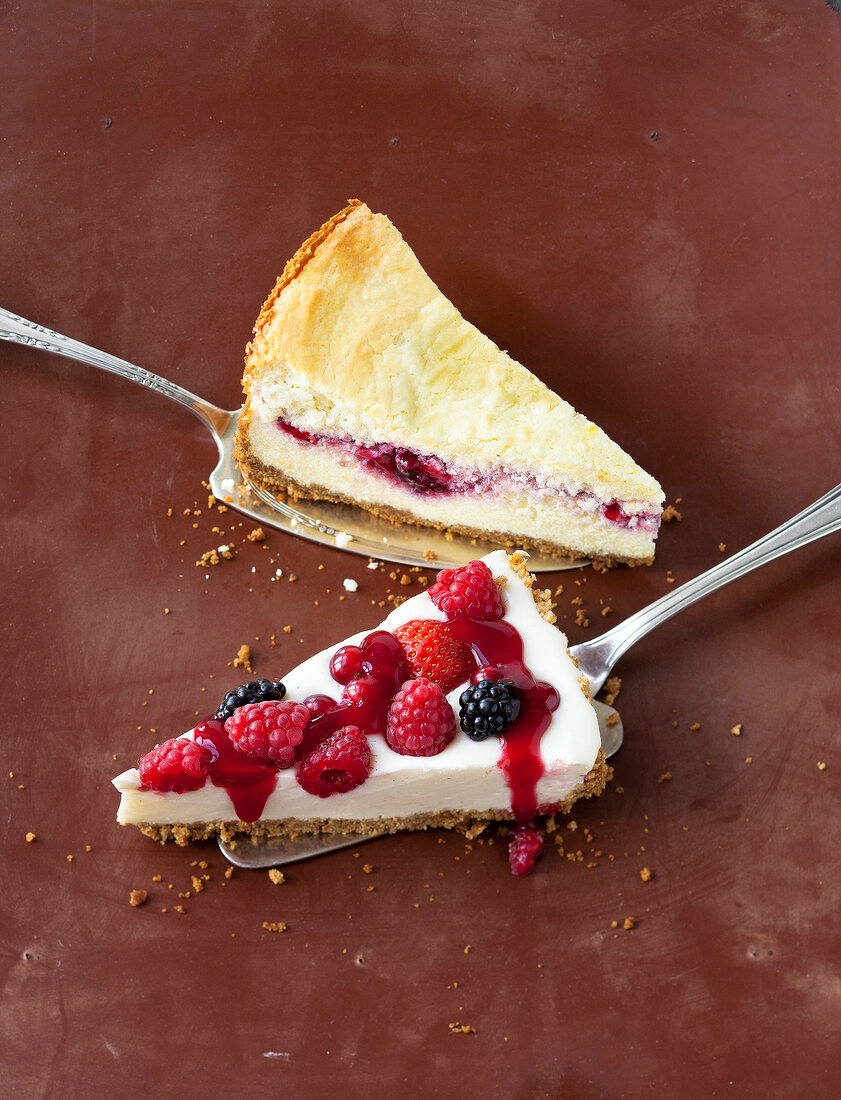 Piece of berry pie and red berry cheesecake on spatula