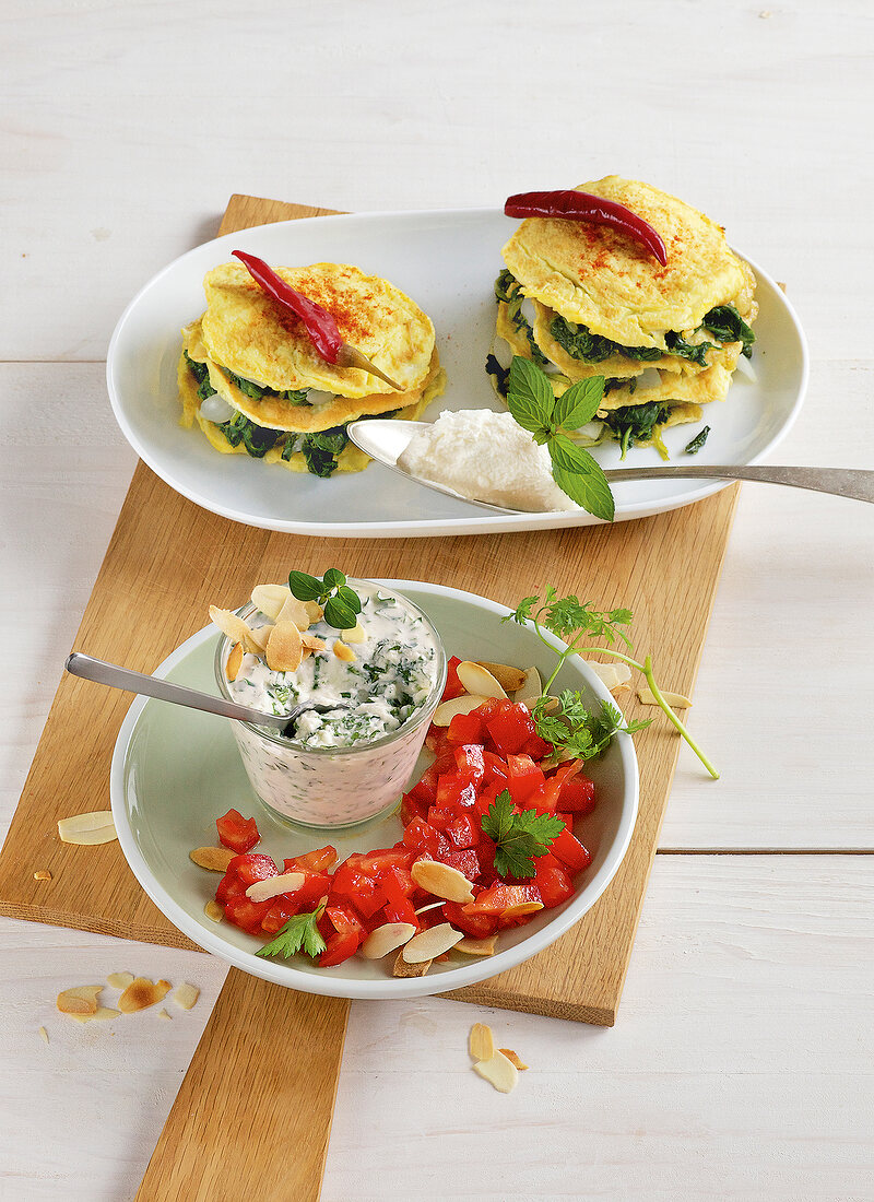 Tomatoes with herb cream and spinach turrets on plates