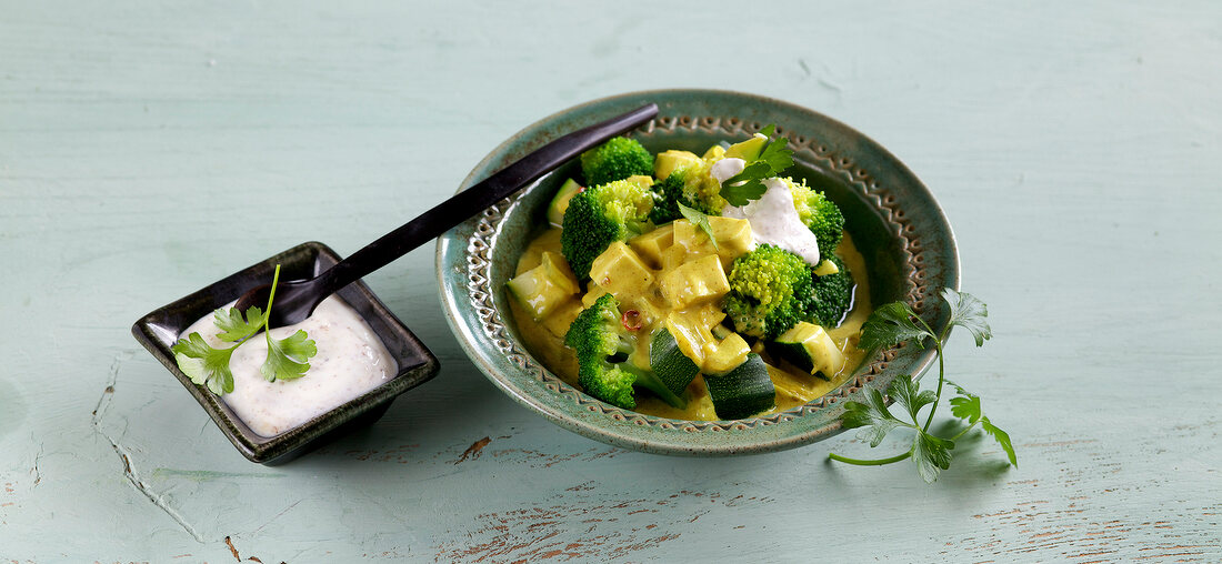 Green coconut curry with almond yogurt in bowl