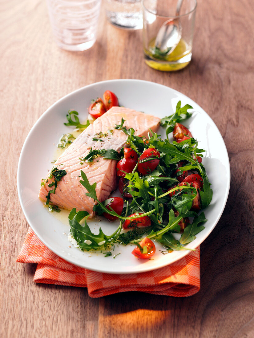 Salmon fillet with rocket leaves on plate