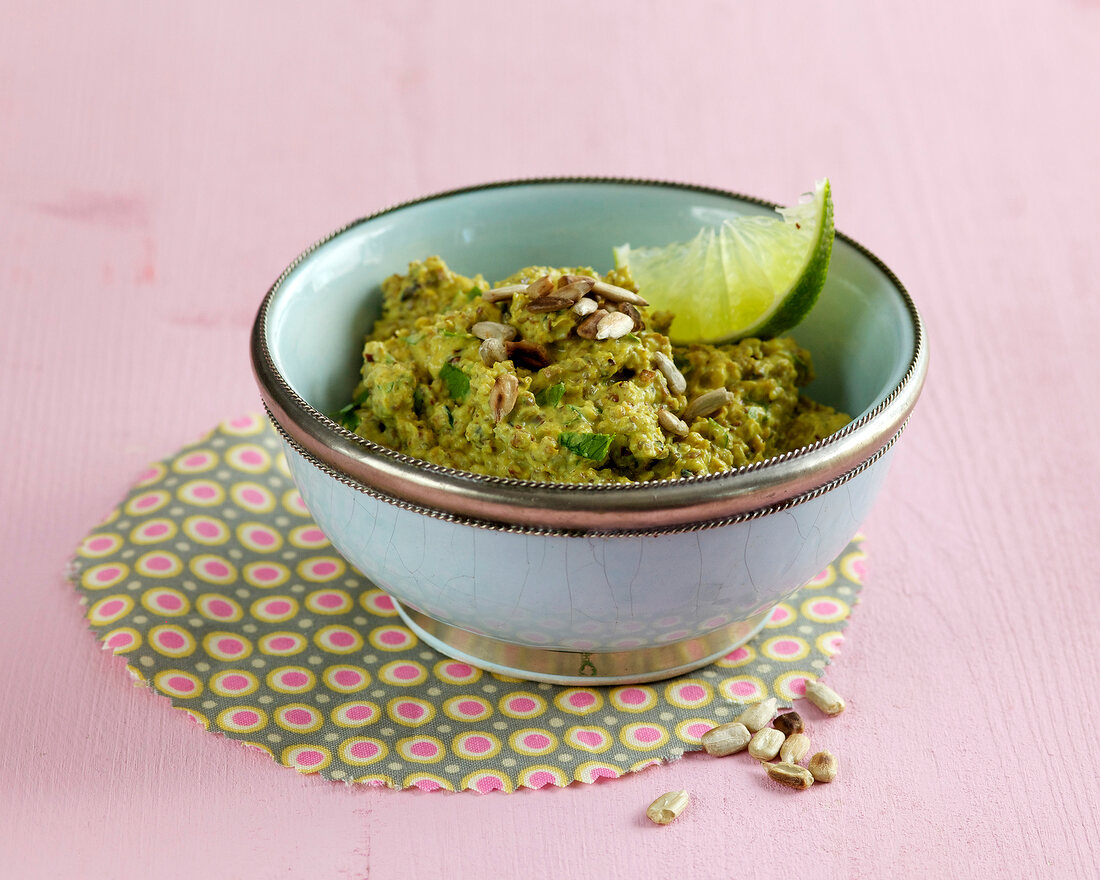 Sunflower seed curry cream with piece of lemon in bowl