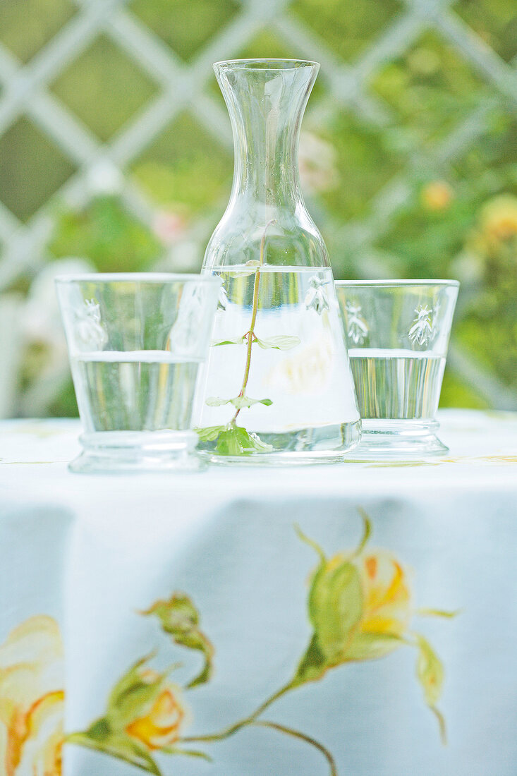 Decanter with two glasses on floral tablecloth