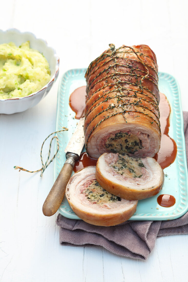 Lamb belly with stuffed nettles and baked garlic on serving dish