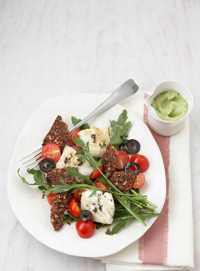 Hake with bread and salad on plate