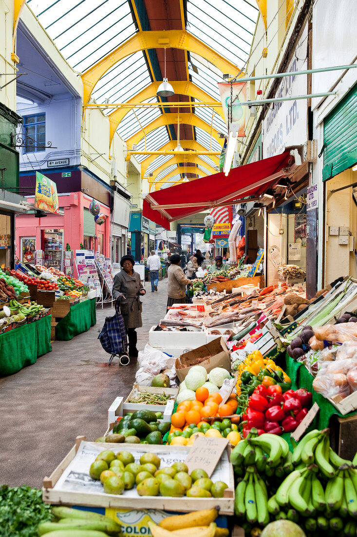 People at market of vegetables in Brixton Village, London, UK