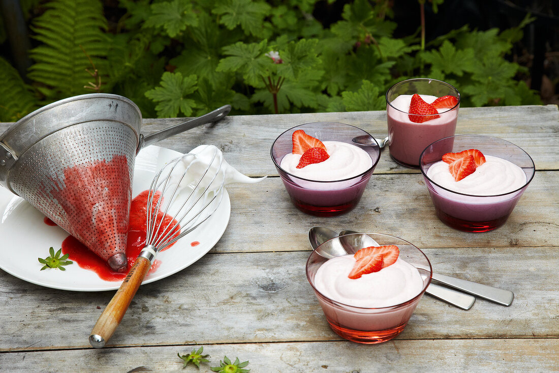 Bowls of strawberry and cream on table