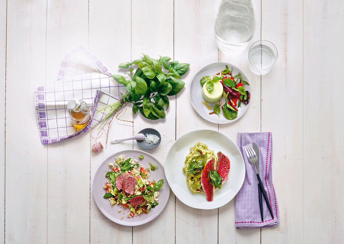 Bulgur salad, potato puree and basil on table