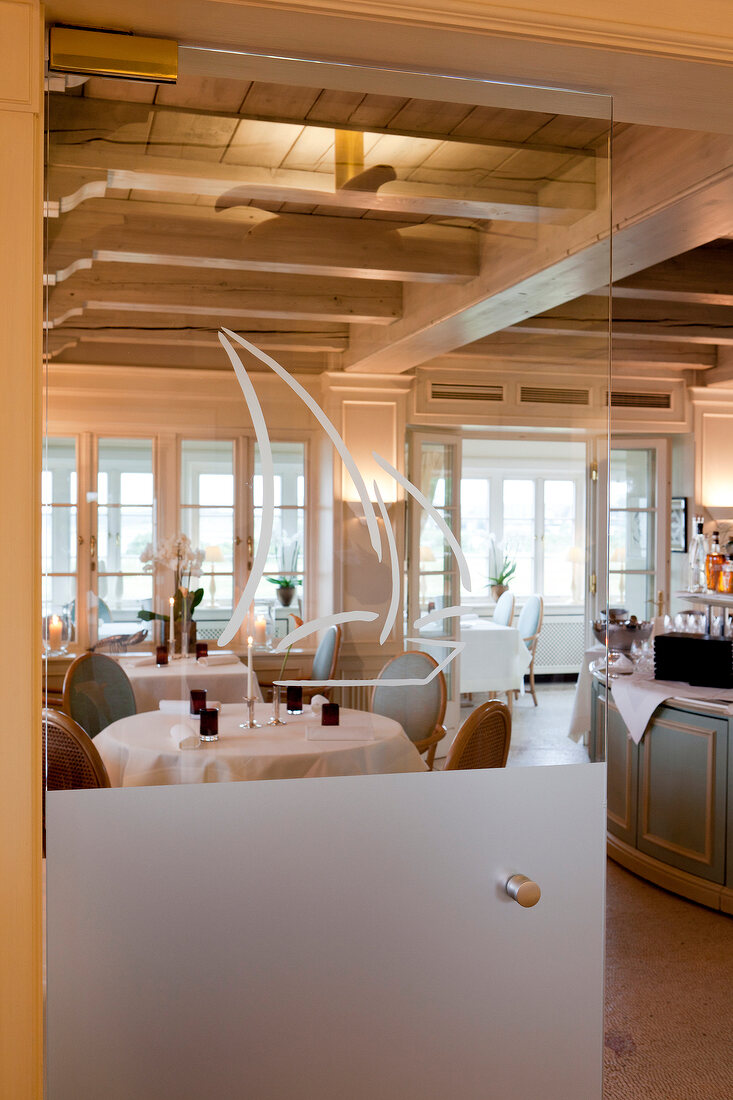 Dining room through glass with ferry motif at Munkmarsch, Sylt, Germany