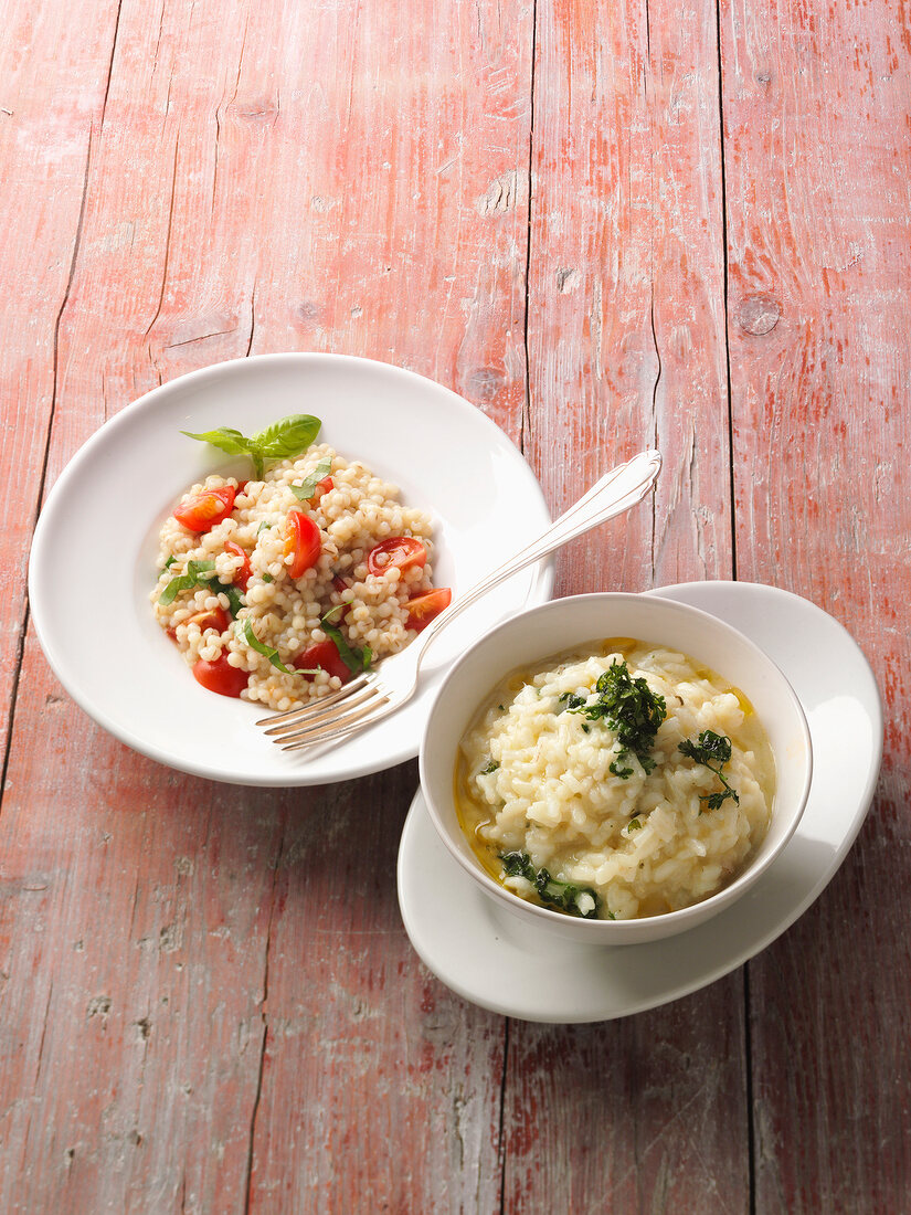 Barley risotto with tomatoes and nettle risotto on wooden table