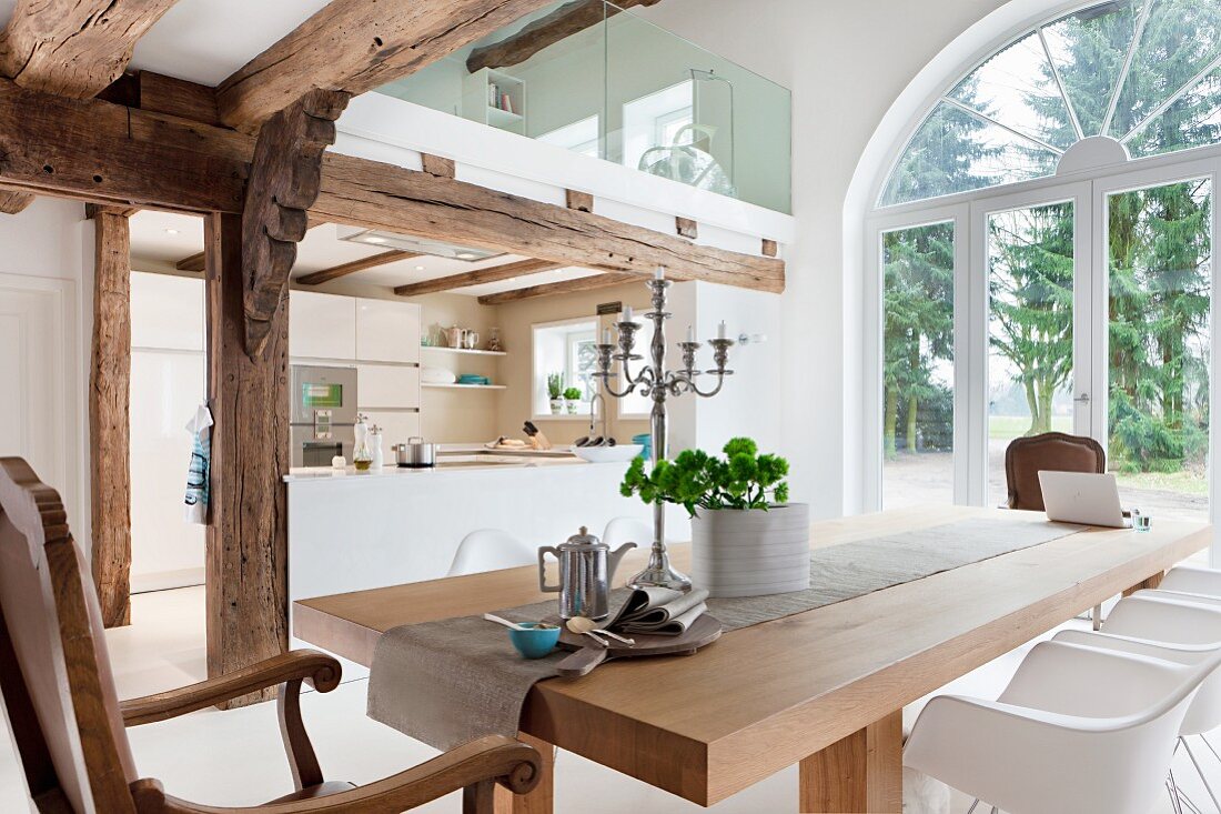 Open-plan interior with wood-beamed ceiling, kitchen, dining area & mezzanine