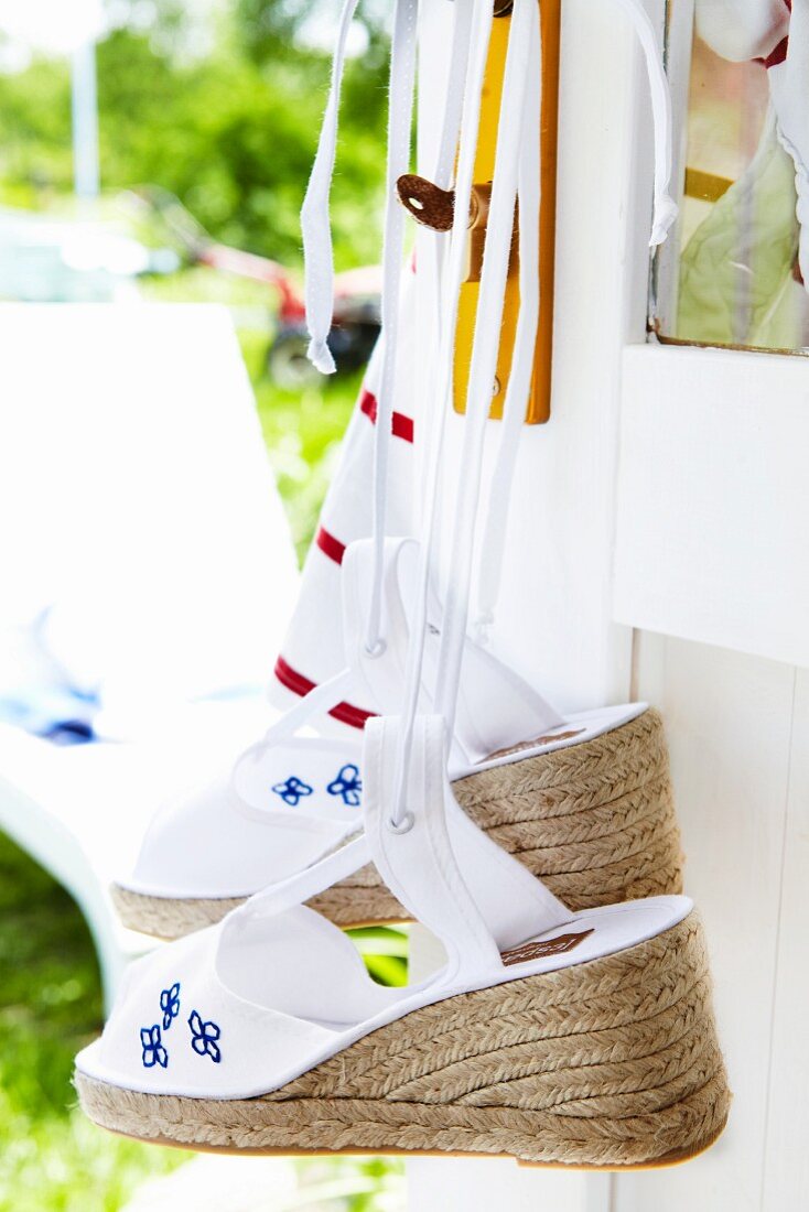 Knitted flower-power style espadrillos hanging on a door handle