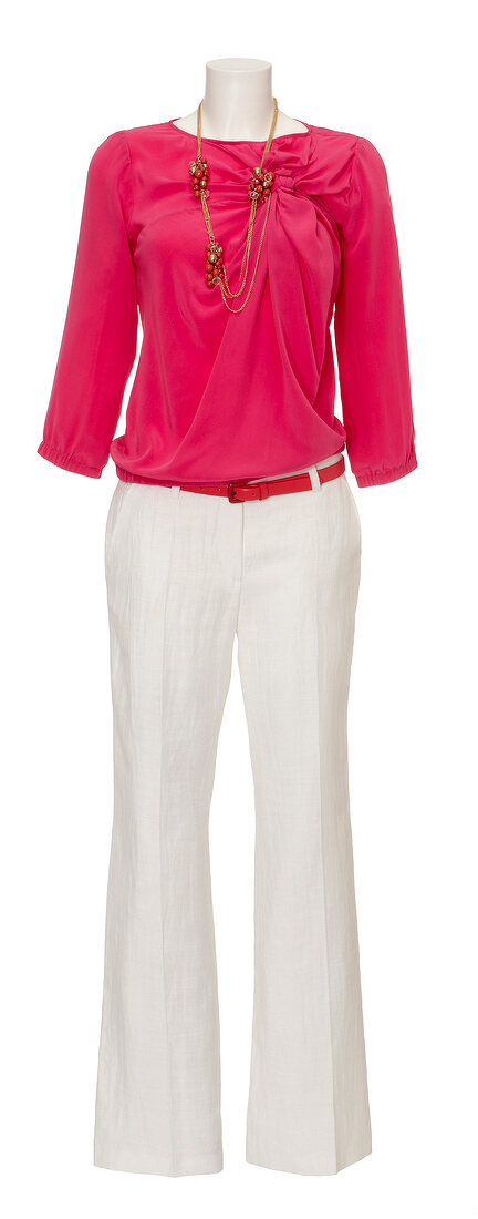 Pink blouse, white linen trousers and chain on mannequin against white background