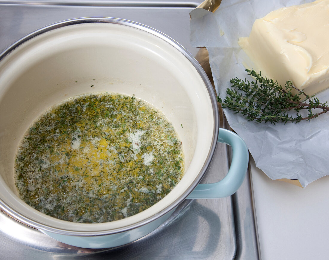 Herb cooked in melted butter while preparing wurz butter, step 2