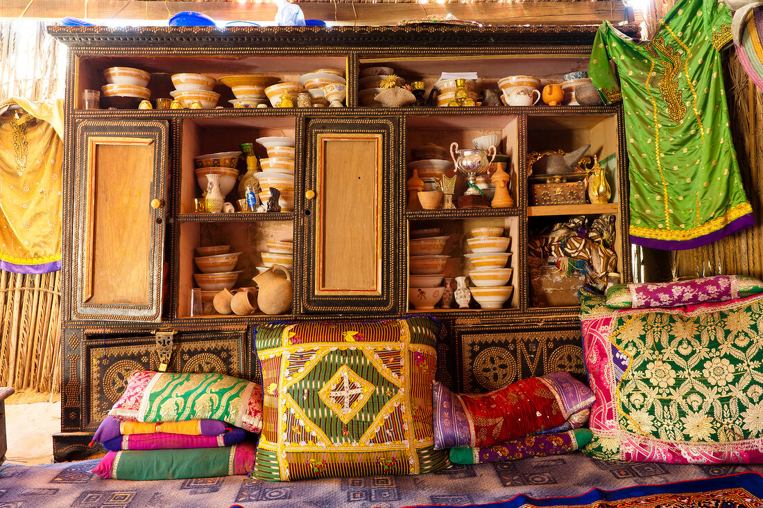 Oriental furnishing shelf with dishes, pillows and clothes