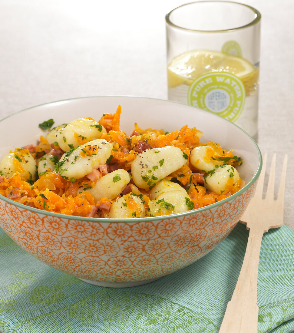 Gnocchi with bacon carrots in bowl