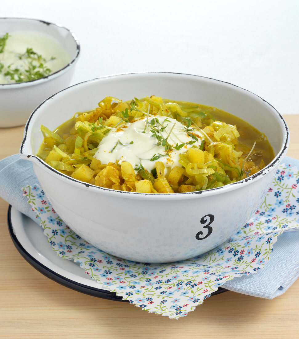 Lentil soup with leek and apple in bowl